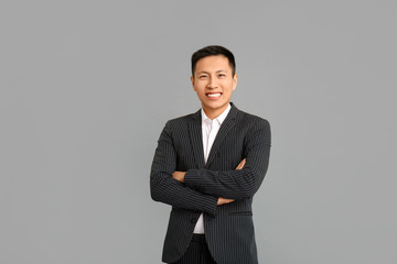 Portrait of Asian businessman on grey background
