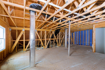 Frame house roof of pipe heating system, house attic under construction frame wooden beams