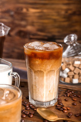 Glass of tasty cold coffee on wooden table