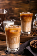 Glass of tasty cold coffee on wooden table