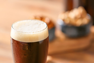 Glass of tasty beer on table, closeup