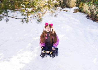 Fototapeta na wymiar Little redhead girl playing in winter with snow enjoying christmas and new year holidays
