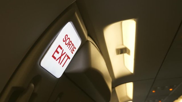 Exit Sortie sign. Interior of jet plane. French and English language. 