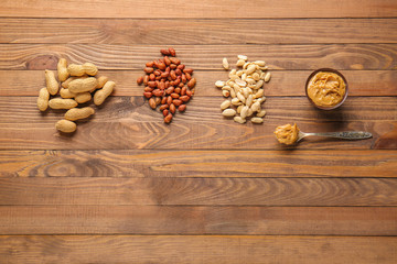 Tasty peanut butter with nuts on wooden background