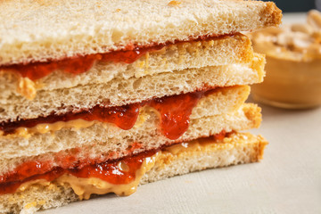 Tasty sandwiches with peanut butter and jam on white background, closeup