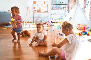 Adorable toddlers playing around lots of toys at kindergarten
