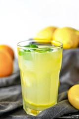 Glass of tasty lemonade on table