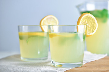 Glasses of tasty lemonade on table