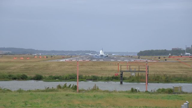 Classic shot of distant Jumbo Jet landing at Reagan National Airport in Washington D.C. as wheels touch down