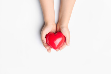 Child hands with red heart on white background. Cardiology concept