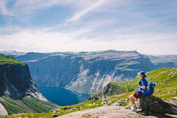 Fototapeta premium Traveling Lifestyle adventure vacations in Norway aerial view landscape. Hike In Norway. Amazing nature view on the way to Trolltunga. Traveller Standing On Famous Norwegian Natural Sight Trolltunga