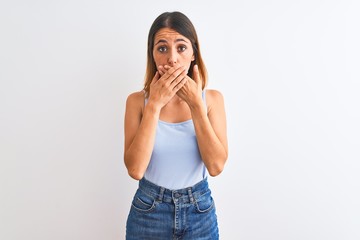 Beautiful redhead woman standing over isolated background shocked covering mouth with hands for mistake. Secret concept.