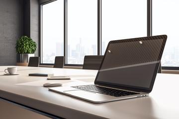 Designer desktop with blank laptop screen