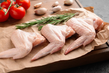 Raw chicken wings on wooden board