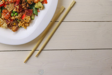 Plate with boiled rice, vegetables and seafood on table, close up