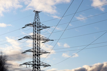 High voltage power line support with electrical wires on cloudy sky. Electricity transmission lines, power supply concept