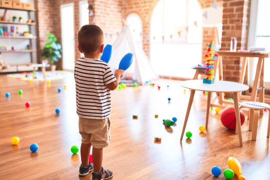 Beautiful toddler boy playing bowling at kindergarten