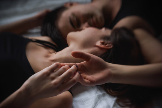 Defocused Top view of couple in love. Close-up portrait of the Lovers who lie on the bed at home, head to head. The morning of the newlyweds, tenderly resting on weekend at home. Concept of tactility