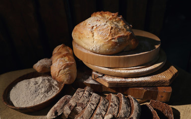 Wheat and rye fresh bread on a wooden table. Bakery.