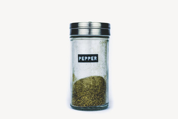 SPICE PEPPER IN GLASS BOTTLE ON WHITE BACKGROUND	