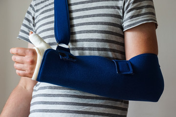 Man with plaster cast on broken thumb,broken wrist, broken hand on arm sling