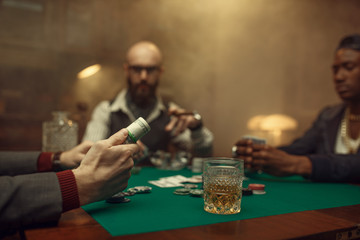 Poker player holds roll of money, casino