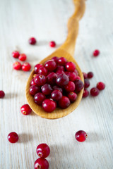 fresh cranberries on white wooden surface