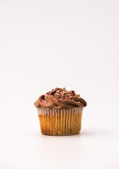 Delicious chocolate muffin, isolated on white background. Muffin and paper, sweet food or unhealthy eating theme.