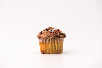 Delicious chocolate muffin, isolated on white background. Muffin and paper, sweet food or unhealthy eating theme.
