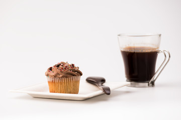 Chocolate muffins on a white background with a cup of coffee and wooden spoon. Homemade baking, Selective focus, close up.