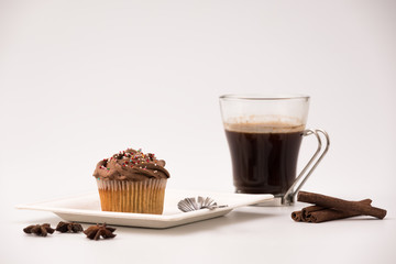 Chocolate Muffin with hot Cup of coffee, cinnamon sticks and Anise stars on a white background
