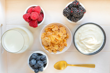 yogurt with whole fresh blueberries raspberries on wooden table. Healthy eating