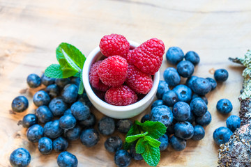 yogurt with whole fresh blueberries raspberries on wooden table. Healthy eating