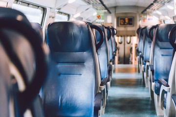 Interior of railway passenger car of the second class in train in Lombardy in Italy. Train interior. Blue seats in a commuter train. Interior of an Italian railway carriage. Empty without people