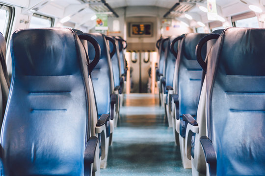 Interior of railway passenger car of the second class in train in Lombardy in Italy. Train interior. Blue seats in a commuter train. Interior of an Italian railway carriage. Empty without people
