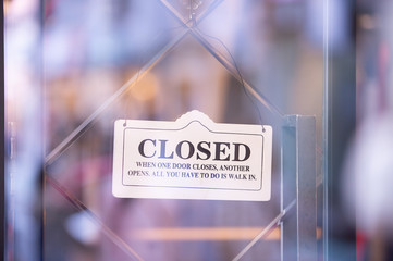 sorry we are closed sign hanging outside a restaurant, store, office or other