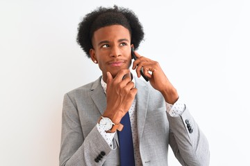 African american businessman talking on the smartphone over isolated white background serious face thinking about question, very confused idea