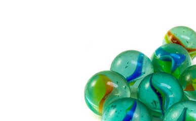 Glass marbles isolated on white background, close-up. Copy space for text.