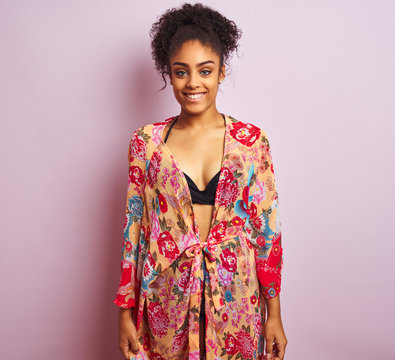 Young beautiful african american woman on vacation standing wearing bikini and colorful caftan