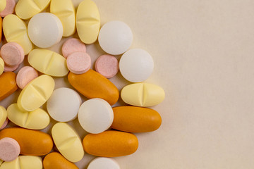 Pills close-up with copy space for text. Different colored medicine pills isolated on light color background.