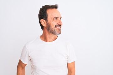Middle age handsome man wearing casual t-shirt standing over isolated white background looking away...