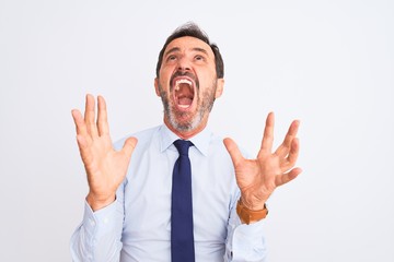 Middle age businessman wearing elegant tie standing over isolated white background crazy and mad shouting and yelling with aggressive expression and arms raised. Frustration concept.