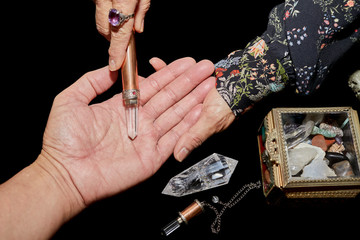 A Spiritual Healer using a Crystal Wand on a Man's hand