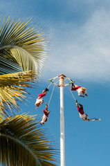 Traditional Mexican act with men in costumes flying around pole 