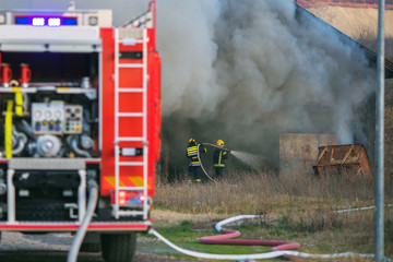 firemen extinguishing a burning house