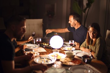 Beautiful family on dinner talking and smiling at terrace