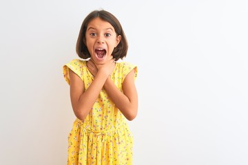 Young beautiful child girl wearing yellow floral dress standing over isolated white background...