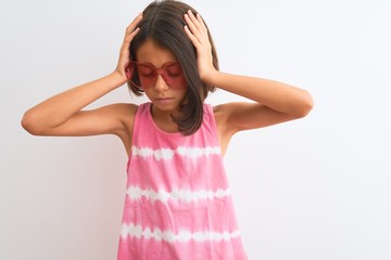 Young beautiful child girl wearing pink t-shirt and sunglasses over isolated white background suffering from headache desperate and stressed because pain and migraine. Hands on head.