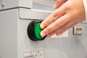 機械のスイッチを入れる手