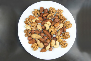 Different kinds of nuts on a white plate. Healthy and protein food